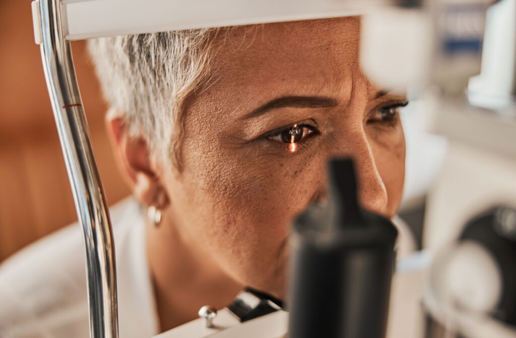 A person calmly sits for a slit-lamp exam at their eye doctor's office.