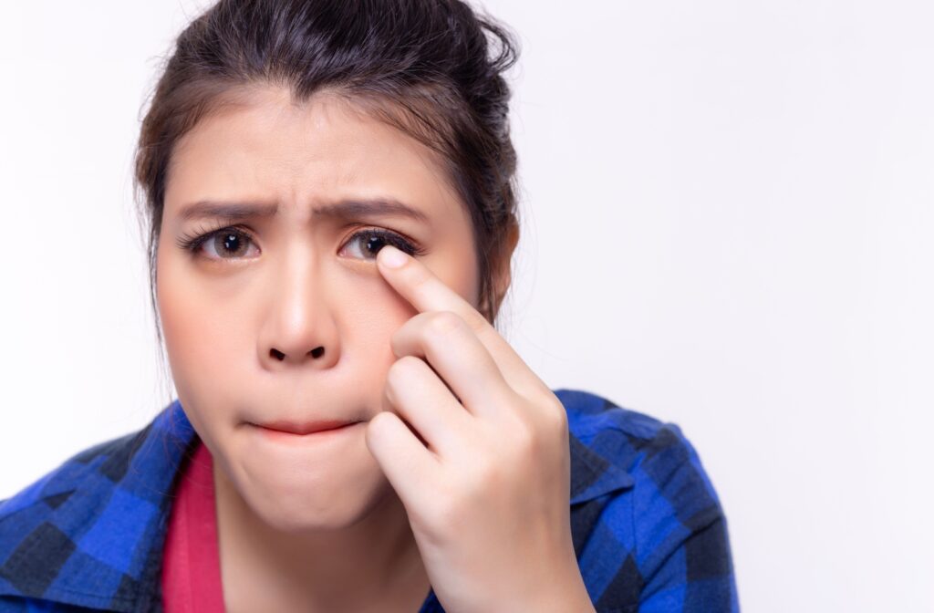 A person examining their eye with a concerned expression.