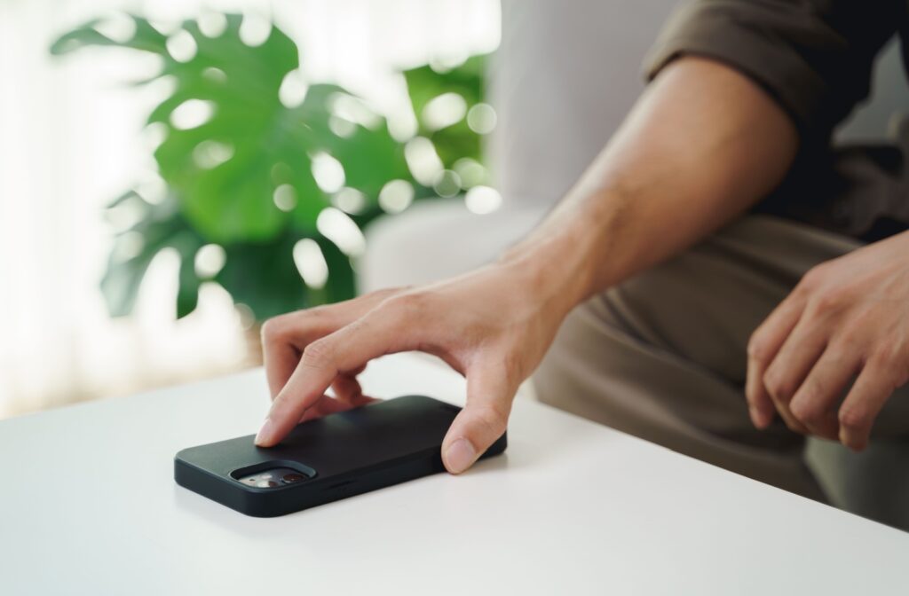 A person setting their phone face down to give their eyes a break from screen time.