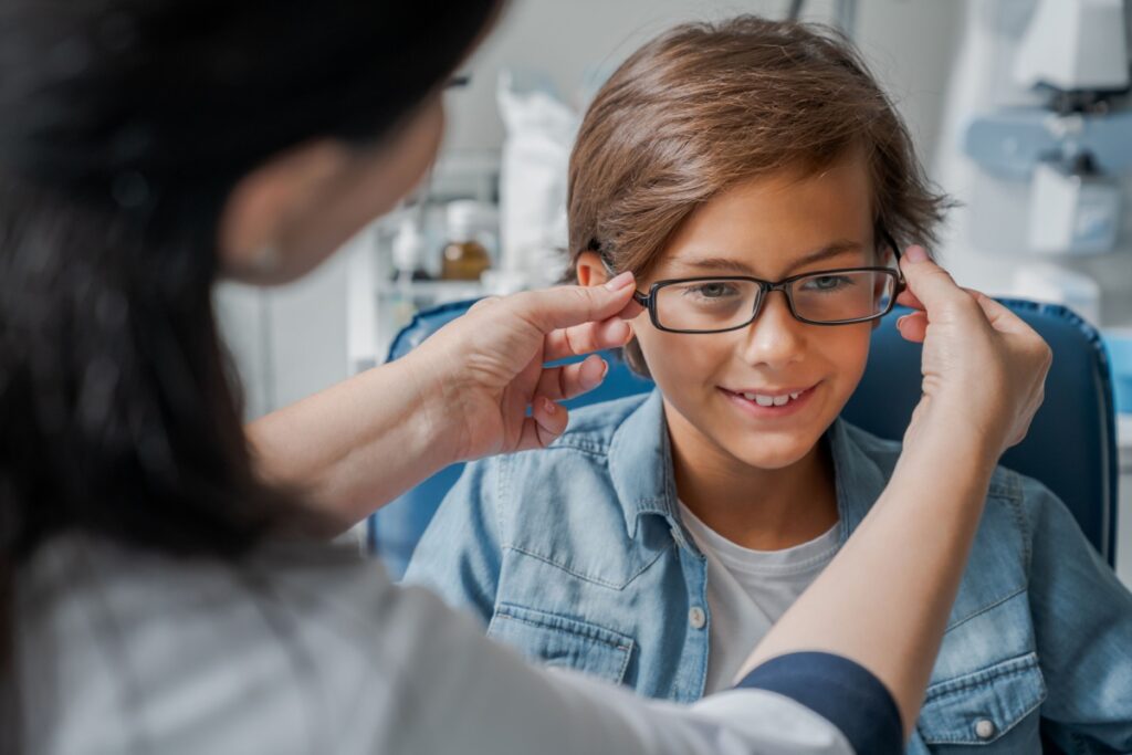 A child having eyeglasses fitted by their optometrist.